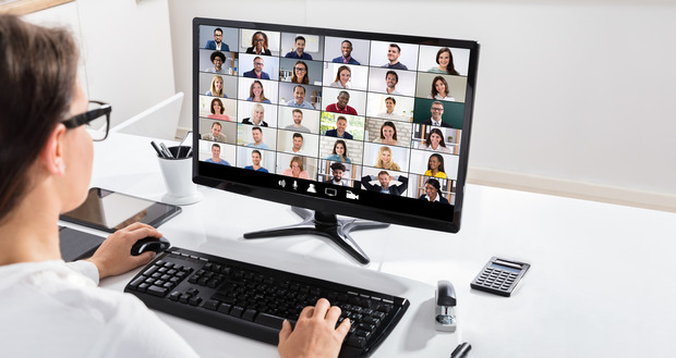 Eine Mitarbeiterin sitzt vor Ihrem PC und nimmt an einer Video-Online-Konferenz teil