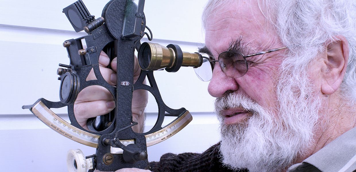 (© ChameleonsEye / Shutterstock Images) Kapitän blickt durch Sextant