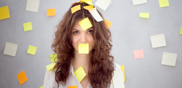 Junge Frau mit Post-it Aufklebern um den Kopf herum
